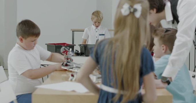 Curious kids working on a functional programable robot during robotics class at school. 4K UHD 60 FPS SLOW MOTION