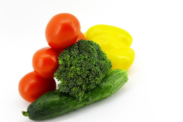 Tomatoes, cucumbers, peppers, yellow large pepper, broccoli cabbage lie on a white background