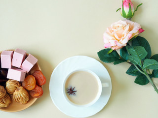 Sweets, marshmallow on a plate, tea on a beige background. Flower. The concept of Ramadan, iftar.