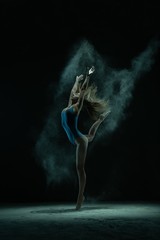 Obraz na płótnie Canvas Graceful blonde jumping in dust cloud profile view