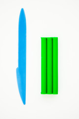 Green plasticine and blue stick on white background