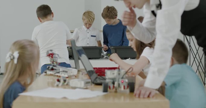 Curious kids working on a functional programable robot during robotics class at school. 4K UHD 60 FPS SLOW MOTION