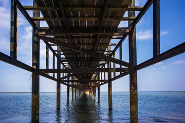 Wood bridge  stands into the sea with blue sky