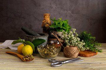 Various herbs and spices, lemons and olive oil on a wooden table