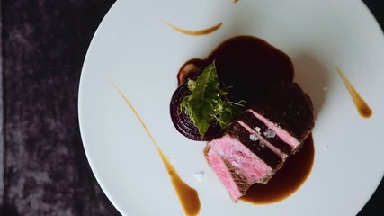 Fine dining decorated dish on a turn table, camera angle from the top. Stake plate on a turn table. Elegance dish made by chef. luxury food.