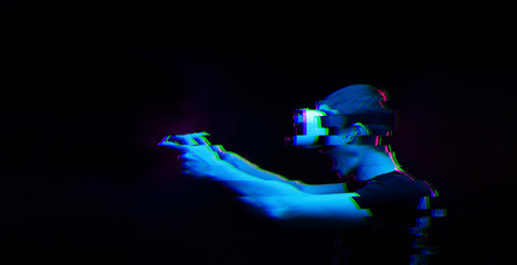 Man with virtual reality headset is playing game. Image with glitch effect.