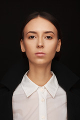 Portrait of a beautiful pacified woman in a white shirt and black jacket. Studio photo session