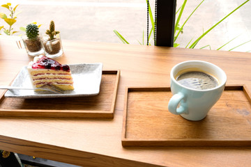 Hot coffee with a blueberry cake in a wooden tray