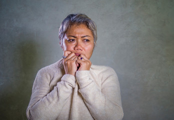dramatic portrait of attractive sad and depressed middle aged Asian woman crying helpless suffering...