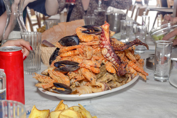 Different, fried seafood on a large dish close-up