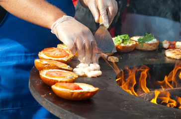 Cooking peeled prawns and grilled burgers