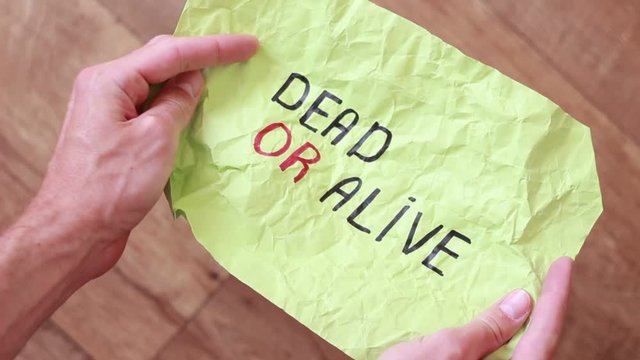 "Dead or alive" inscription on rumpled colorful paper