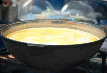 Cooking shrimp soup in a cast iron vat