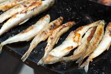 Cooking smelt fish on a brazier