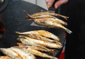 Cooking smelt fish on a brazier