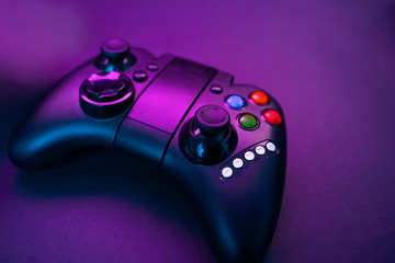 Gamepad on violet table background.