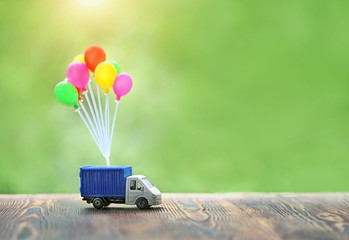 air balloons and truck toy on wood background. truck, Concept for visualization of delivery...