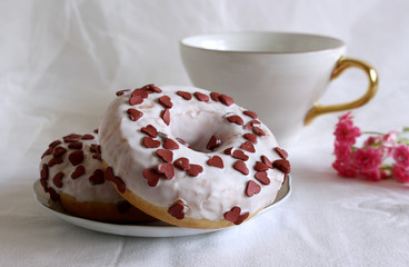 White donuts with chocolate decorationon a wooden table. Retro style. Cup of coffee. Concept of breakfast Food detail. Close up. Pastel color