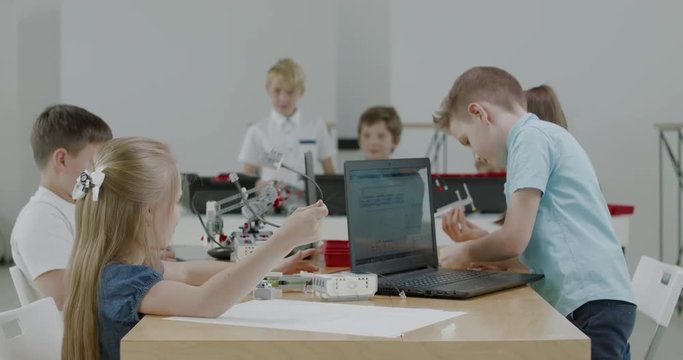 Curious kids working on a functional programable robot during robotics class at school. 4K UHD 60 FPS SLOW MOTION