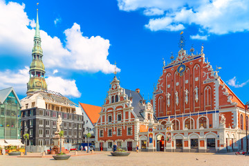 View of the Old Town Ratslaukums square, Roland Statue, The Blackheads House and St Peters Cathedral against blue sky in Riga, Latvia. Summer sunny day - obrazy, fototapety, plakaty