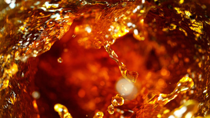 Detail of cola, tea or hard spirit beverages whirl, abstract fresh drink background