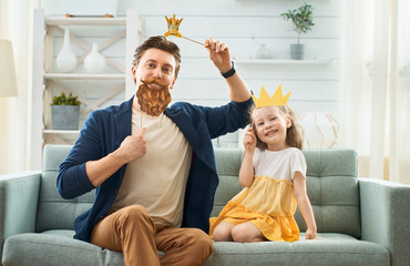 Father and his daughter with a paper accessories.