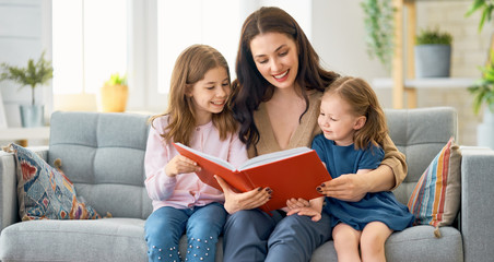 mother reading a book to her daughters