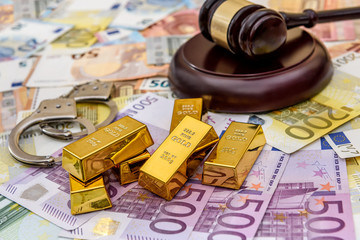 Gold bullions with judge's gavel and handcuffs on euro banknotes