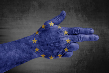 European Union flag painted on male hand like a gun