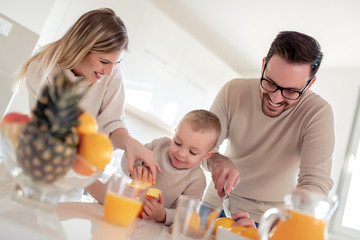 Obraz na płótnie Canvas Happy family make orange juice