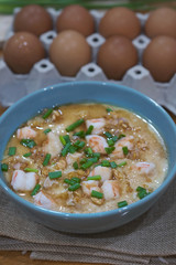 Steamed egg custard cuisine in a blue bowl with minced pork, sausage and shrimp. Or Only with egg, water, salt and some sesame oil, you can make this super smooth custard.