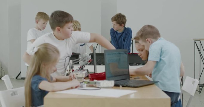 Curious kids working on a functional programable robot during robotics class at school. 4K UHD 60 FPS SLOW MOTION