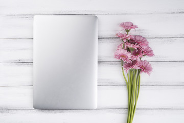 Flat lay composition of flowers and laptop