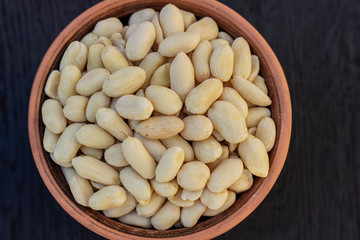 peanuts in ceramic bowl on oak table