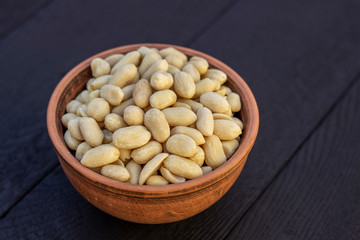 peanuts in ceramic bowl on oak table