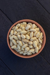 peanuts in ceramic bowl on oak table