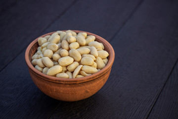 peanuts in ceramic bowl on oak table
