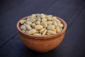 peanuts in ceramic bowl on oak table
