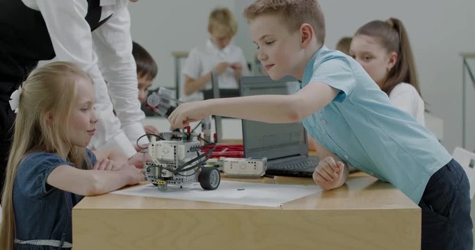 Curious kids working on a functional programable robot during robotics class at school. 4K UHD 60 FPS SLOW MOTION