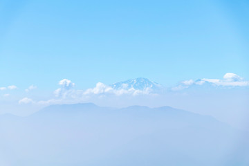 Abstract cascade mountain chains silhouette landscape nackground in a light blue mist sky in morning Andes