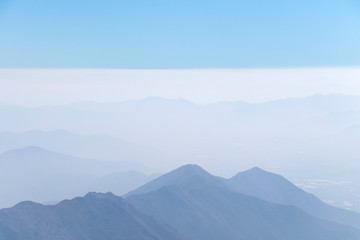 Obraz premium Abstract cascade mountain chains silhouette landscape nackground in a light blue mist sky in morning Andes