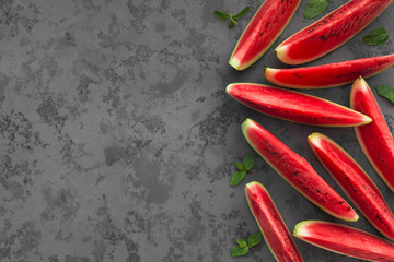 Cut ripe watermelon slices on dark grey background