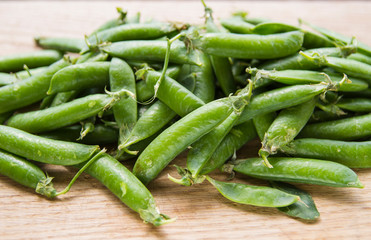green pea pods on wooden background