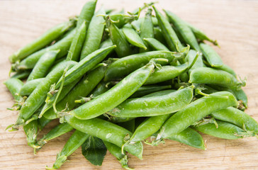 green pea pods on wooden background