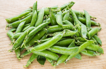 green pea pods on wooden background