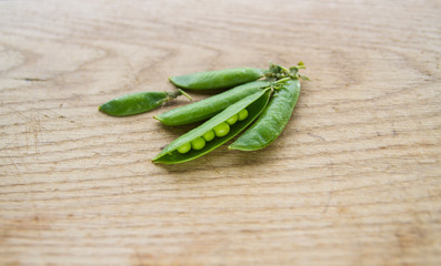 on wooden board lies green peas