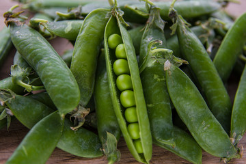 green pea pods on wooden background