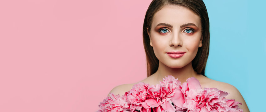 Woman Beauty Face With Tender Makeup, Pink Lips And Blue Eyes With Pions On Pastel Color Background. Beauty Makeup