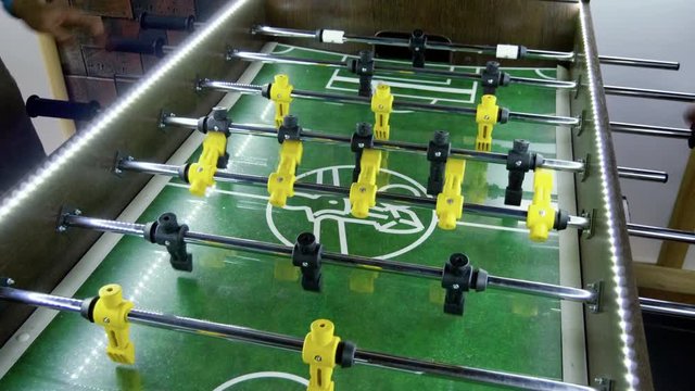 Sport, game concept. Foosball. People playing a table football or kicker with miniature players. 4K