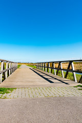 hiking path and wooden bridge in recreation park Zuidpolder in Barendrecht, The Netherlands. Blue sky, copy space